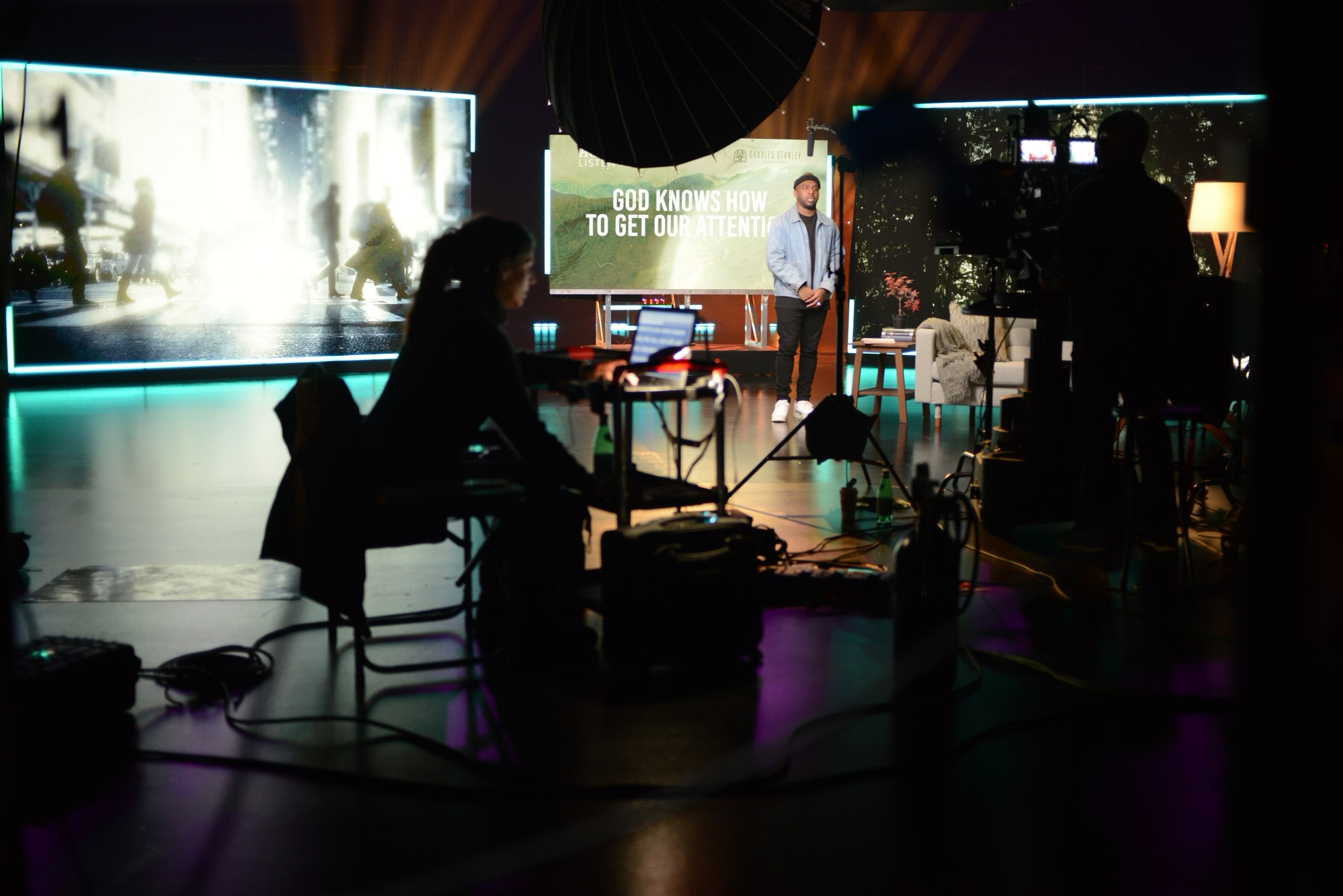 B Prompt operator running a teleprompter from the control desk as a presenter rehearses on a lit studio stage